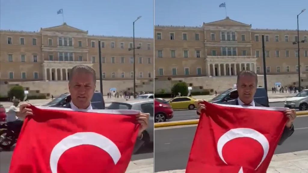 Ο Τούρκος πολιτικός Μουσταφά Σαριγκιούλ ξεδιπλώνει την τουρκική σημαία στο Σύνταγμα. Εικόνα: Βίντεο twitter.com